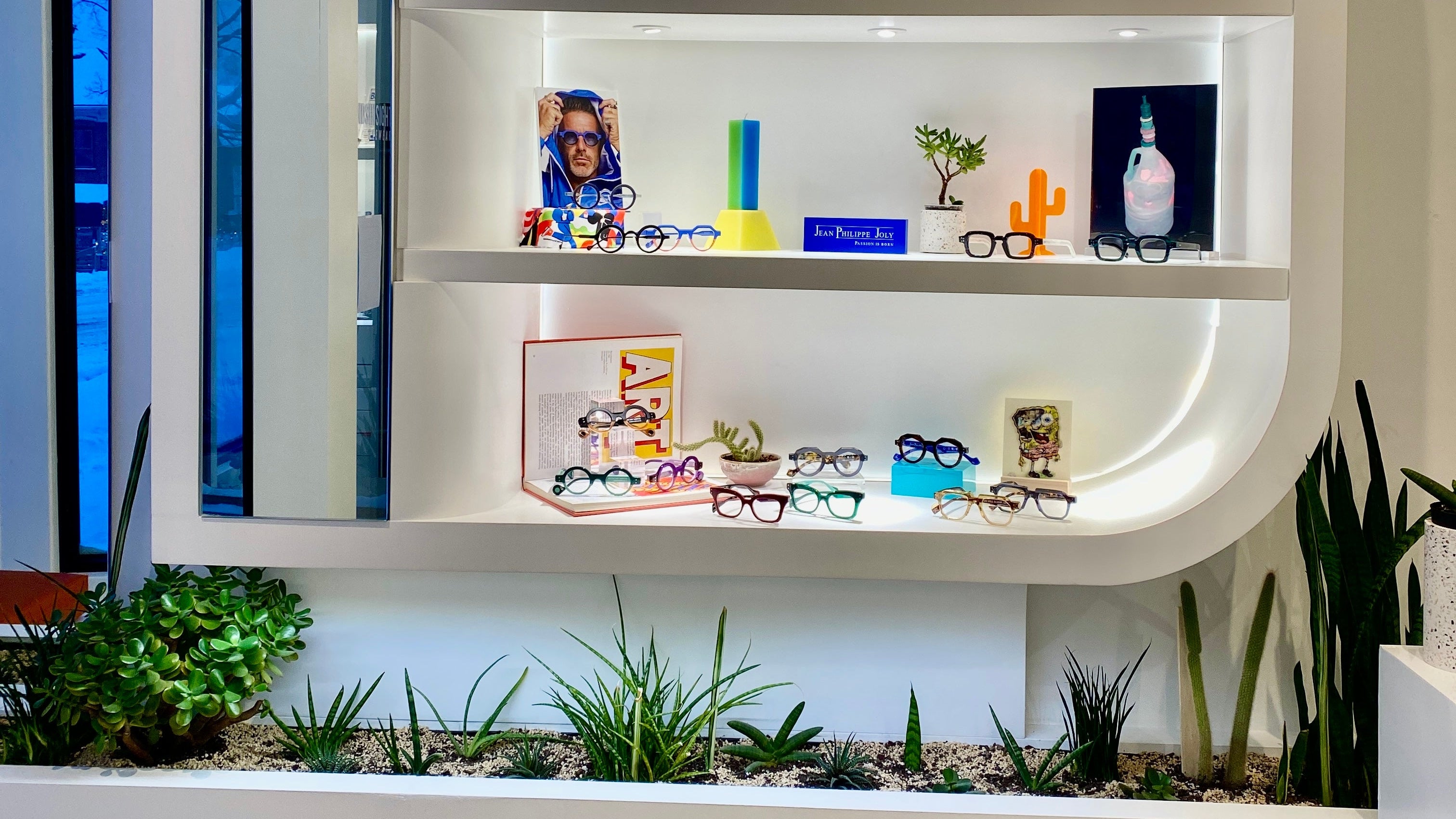 Modern interior design with a white curved shelf displaying various items against a light gray wall.